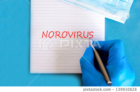 Norovirus medical words symbol. Concept words Norovirus on beautiful white note. Beautiful blue background. Doctor hand in blue medical glove. Medical mask. Medical Norovirus concept. Copy space. Norovirus medical words symbol. Concept words Norovirus on beautiful white note. Beautiful blue background. Doctor hand in blue medical glove. Medical mask. Medical Norovirus concept. Copy space. 139910828