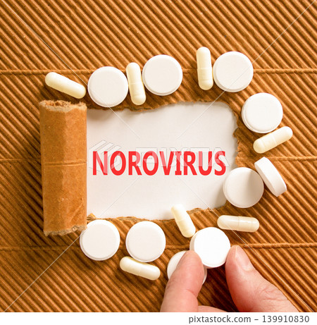Norovirus medical words symbol. Concept words Norovirus on beautiful white paper. Beautiful brown background. Beautiful white pills. Doctor hand. Medical Norovirus concept. Copy space. Norovirus medical words symbol. Concept words Norovirus on beautiful white paper. Beautiful brown background. Beautiful white pills. Doctor hand. Medical Norovirus concept. Copy space. 139910830