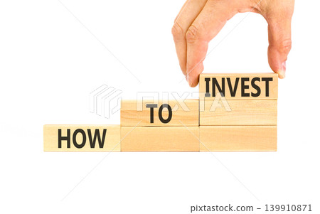 How to invest words symbol. Concept words How to invest on beautiful wooden blocks. Beautiful white background. Businessman hand. Business and how to invest concept. Copy space. 139910871