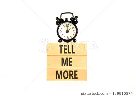 Tell me more words symbol. Concept words Tell me more on beautiful wooden blocks. Beautiful white background. Black alarm clock. Business and tell me more concept. Copy space. Tell me more words symbol. Concept words Tell me more on beautiful wooden blocks. Beautiful white background. Black alarm clock. Business and tell me more concept. Copy space. 139910874