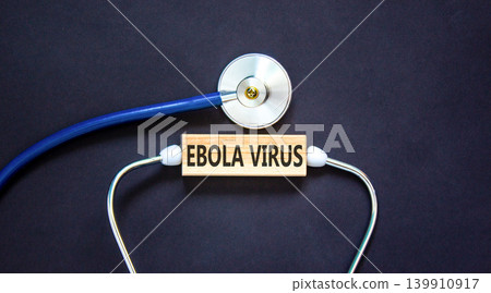 Ebola virus medical words symbol. Concept words Ebola virus on beautiful wooden block. Beautiful black background. Stethoscope. Medical Ebola virus concept. Copy space. Ebola virus medical words symbol. Concept words Ebola virus on beautiful wooden block. Beautiful black background. Stethoscope. Medical Ebola virus concept. Copy space. 139910917