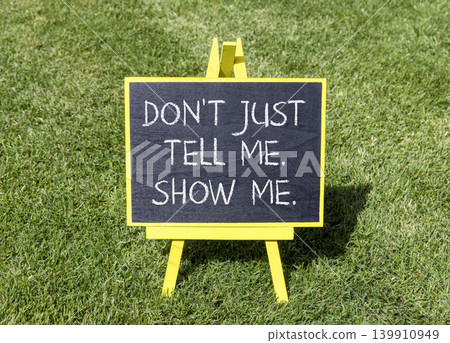 Tell or show symbol. Concept words Do not just tell me, show me on beautiful blackboard. Beautiful green grass lawn background. Business tell or show concept. Copy space. Tell or show symbol. Concept words Do not just tell me, show me on beautiful blackboard. Beautiful green grass lawn background. Business tell or show concept. Copy space. 139910949