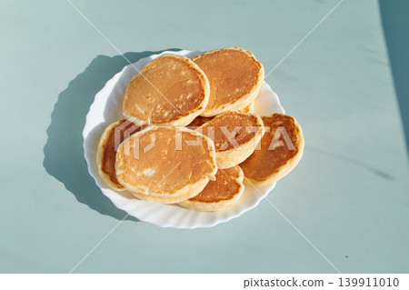 Stack of Fluffy Golden Pancakes on a Plate, natural sunlight 139911010