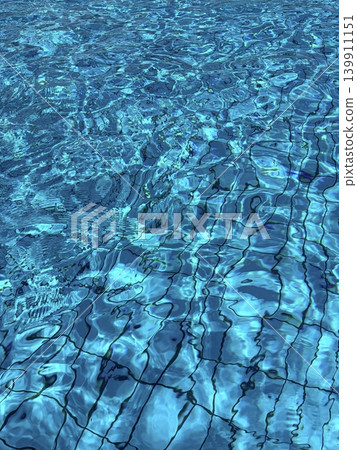 A radical image of clear, transparent blue water in a tiled swimming pool. Water ripples and sun glare in the pool. A radical image of clear, transparent blue water in a tiled swimming pool. Water ripples and sun glare in the pool. 139911151