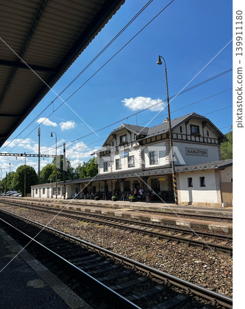 Train station building with traditional architecture and platform, surrounded by trees and Train station building with traditional architecture and platform, surrounded by trees and 139911180