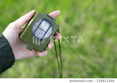 Magnetic compass held in a human palm, close-up, with space for text. Useful device for hiking, trekking, and map reading during adventures. Magnetic compass held in a human palm, close-up, with space for text. Useful device for hiking, trekking, and map reading during adventures. 139911368