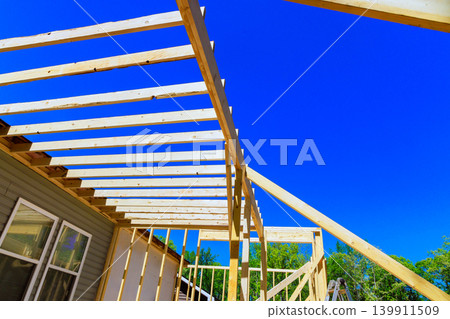 Workers are building roof trusses frame for house with wooden beams Workers are building roof trusses frame for house with wooden beams 139911509