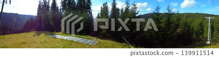 Panoramic mountain landscape from a ski slope with forests and meadows. Panoramic mountain landscape from a ski slope with forests and meadows. 139911514