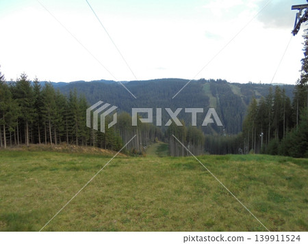 Beskydy Mountains under cold sun with forests, meadows, and hills in clouds Beskydy Mountains under cold sun with forests, meadows, and hills in clouds 139911524