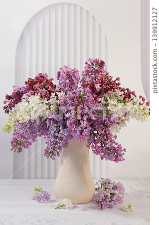 Abstract floral arrangement and banner for the screen, still life with spring flowers. Beautiful spring blooming lilac branches in a vase on an elegant background. Floral holiday card Abstract floral arrangement and banner for the screen, still life with spring flowers. Beautiful spring blooming lilac branches in a vase on an elegant background. Floral holiday card 139912127