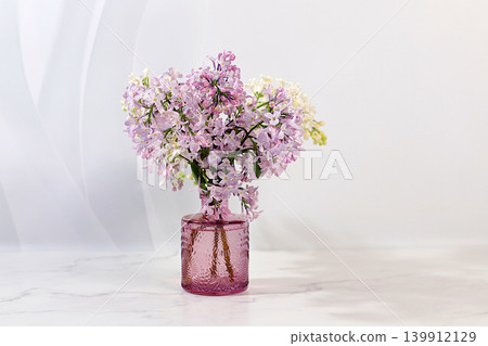 Beautiful spring blooming lilac branches in vase on elegant background. Abstract flower arrangement and banner for screen, Still life with place for text, Floral holiday card Beautiful spring blooming lilac branches in vase on elegant background. Abstract flower arrangement and banner for screen, Still life with place for text, Floral holiday card 139912129