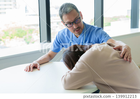 A woman grieves after receiving a diagnosis from her doctor. 139912213
