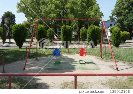 A park with playground equipment - Swings 139912568