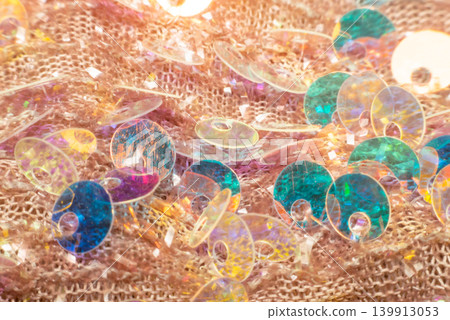 Closeup colorful sequins scattered textured fabric shiny reflections vibrant light decorative pattern suitable for fashion design festive background Closeup colorful sequins scattered textured fabric shiny reflections vibrant light decorative pattern suitable for fashion design festive background 139913053