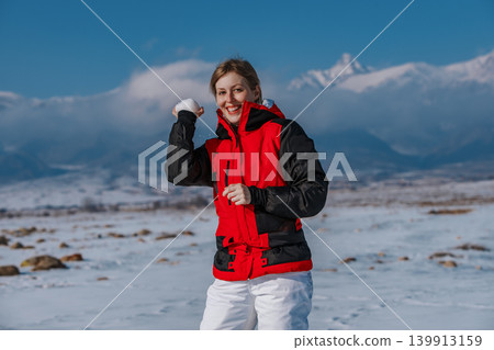 Young woman throwing a snowball on mountain background 139913159
