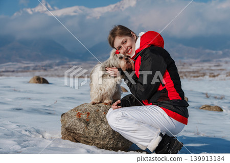 Young woman tourist with dog on winter mountains background Young woman tourist with dog on winter mountains background 139913184