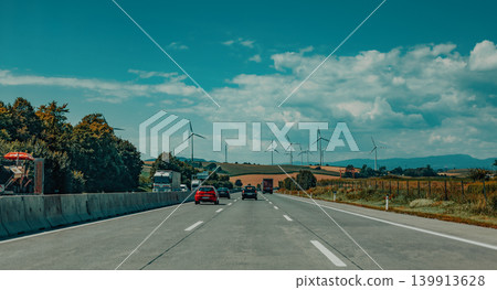 View of the highway and field with wind turbines View of the highway and field with wind turbines 139913628