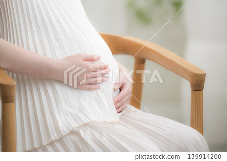 一位日本孕婦面帶微笑,將手放在肚子上;一張孕婦生活照顯示她面帶微笑地坐著,沒有臉部特寫,只有雙手。 一位日本孕婦面帶微笑,將手放在肚子上;一張孕婦生活照顯示她面帶微笑地坐著,沒有臉部特寫,只有雙手。 139914200