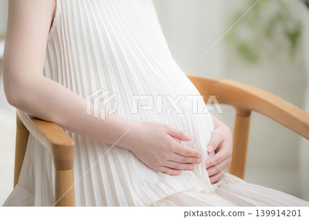 一位日本孕婦面帶微笑,將手放在肚子上;一張孕婦生活照顯示她面帶微笑地坐著,沒有臉部特寫,只有雙手。 一位日本孕婦面帶微笑,將手放在肚子上;一張孕婦生活照顯示她面帶微笑地坐著,沒有臉部特寫,只有雙手。 139914201