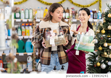 Woman seller offers cosmetics gift sets for christmas to woman buyer Woman seller offers cosmetics gift sets for christmas to woman buyer 139914241