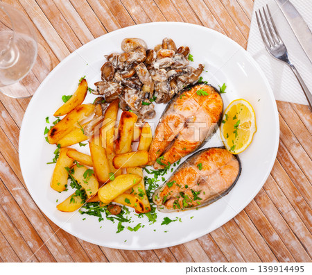 Salmon with potatoes and mushrooms is tasty dish in the kitchen 139914495