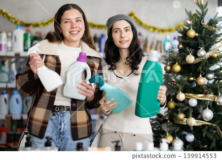 Two women choose detergents and sprays at great Christmas discounts Two women choose detergents and sprays at great Christmas discounts 139914553