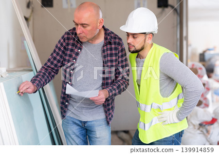 Construction manager discussing work with builder Construction manager discussing work with builder 139914859