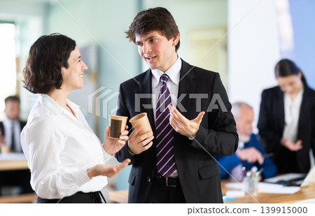 Man and a woman with hot drinks at work 139915000