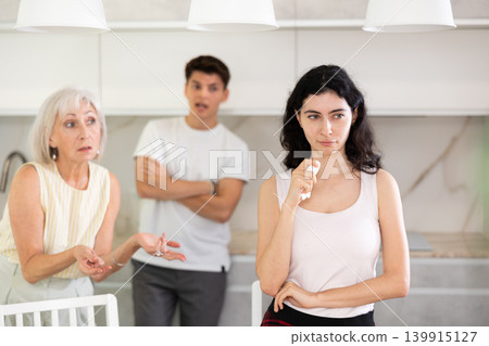 Sad woman dont speaking after discord with mother and husband standing behind 139915127