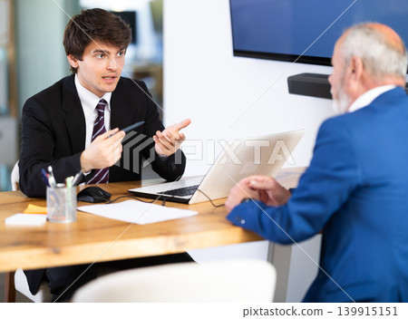 Man bank employees discussing financial documents and opening a deposit. Man bank employees discussing financial documents and opening a deposit. 139915151