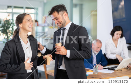Man and a woman with hot drinks at work Man and a woman with hot drinks at work 139915170