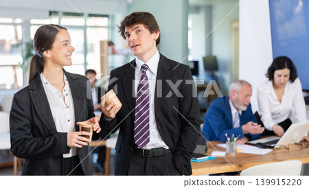 Man and a woman with hot drinks at work Man and a woman with hot drinks at work 139915220