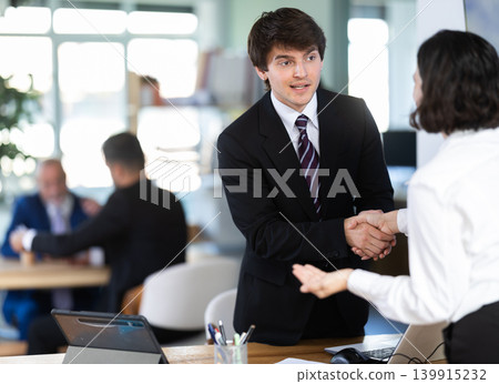 Young bank manager shaking hands with adult female client 139915232