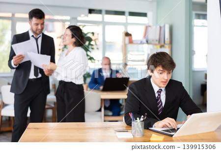 Young man working on laptop in office Young man working on laptop in office 139915306