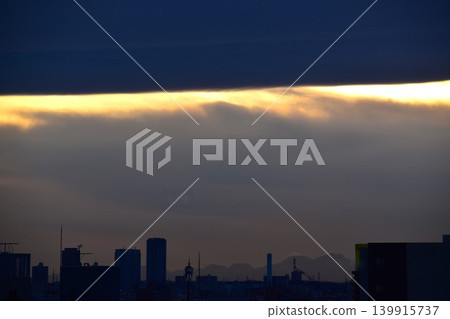 Sunset peeking through a gap in the large, overhanging clouds Sunset peeking through a gap in the large, overhanging clouds 139915737