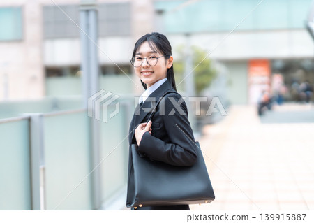 一位身著職業套裝的女商人正在通勤上班。 139915887