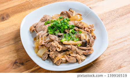 A photo of a Japanese-style stir-fry dish of pork and mushrooms topped with green onions. A photo of a Japanese-style stir-fry dish of pork and mushrooms topped with green onions. 139916519
