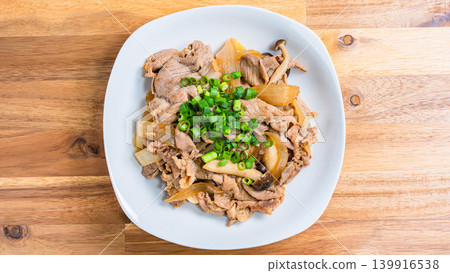 A photo of a Japanese-style stir-fry dish of pork and mushrooms topped with green onions. A photo of a Japanese-style stir-fry dish of pork and mushrooms topped with green onions. 139916538