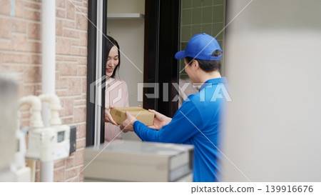 Delivery person delivering a small cardboard box Delivery person delivering a small cardboard box 139916676