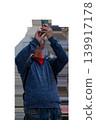 A man takes a photo or shoots a video on a smartphone, the image is on a transparent background. High quality photo 139917178