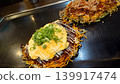 Delicious-looking Hiroshima-style okonomiyaki and modern-yaki being grilled on a hot plate. 139917474