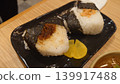 Delicious-looking rice balls and pickled radish served on a black plate. 139917488