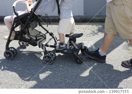 父母和孩子使用嬰兒車踏板移動。 139917555