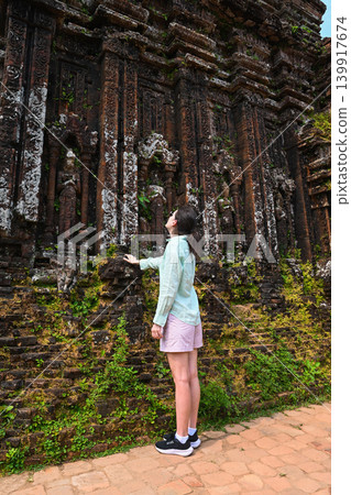 A 30 year old Russian woman tourist explores the ancient ruins of My Son sanctuary of Champa civilization near Da Nang in Quang Nam province Vietnam A 30 year old Russian woman tourist explores the ancient ruins of My Son sanctuary of Champa civilization near Da Nang in Quang Nam province Vietnam 139917674