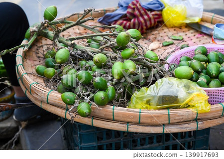 A fresh bunch of green Areca nuts displayed on a traditional bamboo round tray at a local street market stall in Hoi An Vietnam A fresh bunch of green Areca nuts displayed on a traditional bamboo round tray at a local street market stall in Hoi An Vietnam 139917693