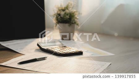 Calculator and pen placed on individual income tax return documents on office desk for financial calculation, accounting review, expense reporting, budget planning, and tax preparation. Calculator and pen placed on individual income tax return documents on office desk for financial calculation, accounting review, expense reporting, budget planning, and tax preparation. 139917855