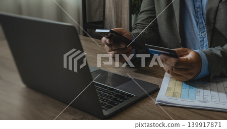 Person using smartphone and credit card beside laptop and financial document on office desk for online payment, digital banking, expense management, transaction verification, and remote finance Person using smartphone and credit card beside laptop and financial document on office desk for online payment, digital banking, expense management, transaction verification, and remote finance 139917871