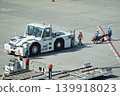 Airline ground crew and tow truck working on the airport apron. 139918023