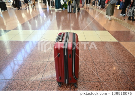 Red travel suitcases placed in airport and train station lobbies Red travel suitcases placed in airport and train station lobbies 139918076