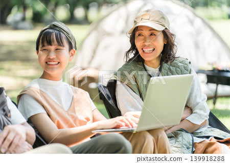 Families using tablets to search and watch videos in parks and campgrounds. Families using tablets to search and watch videos in parks and campgrounds. 139918288